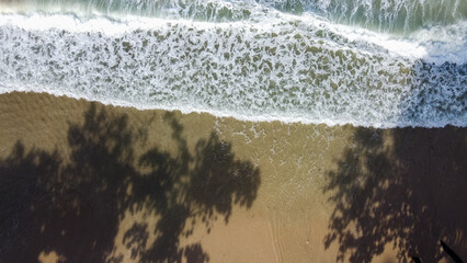 white waves and sandy beach, Beach with tree shadows.