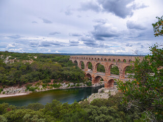 Panoramic view of ancient old Roman Aqueduct Pont du Gard ear Vers-Pon-du-Gard, Occitanie, France, Europe. Landmark over the River Gardon. Unesco world heritage site near Nimes, Languedoc-Roussillon