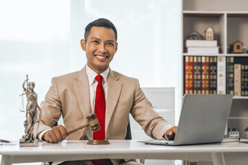 Middle-aged Asian indian people male lawyer meticulously reviews legal documents. Courtroom judge...