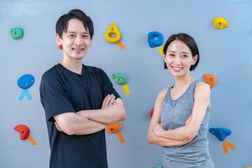 Fototapeta premium クライミングウォールの前でポーズをとる2人