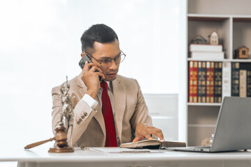 Middle-aged Asian indian people male lawyer meticulously reviews legal documents. Courtroom judge...