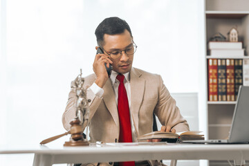 Middle-aged Asian indian people male lawyer meticulously reviews legal documents. Courtroom judge...