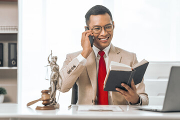 Middle-aged Asian indian people male lawyer meticulously reviews legal documents. Courtroom judge...