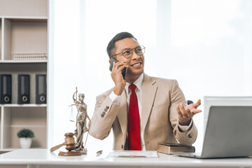 Middle-aged Asian indian people male lawyer meticulously reviews legal documents. Courtroom judge...