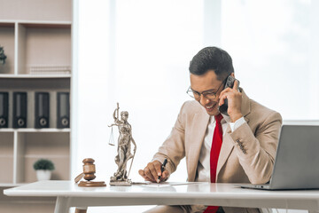 Middle-aged Asian indian people male lawyer meticulously reviews legal documents. Courtroom judge...