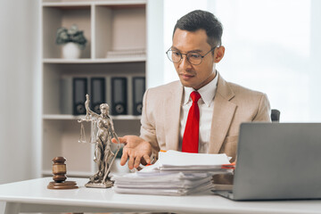 Middle-aged Asian indian people male lawyer meticulously reviews legal documents. Courtroom judge...