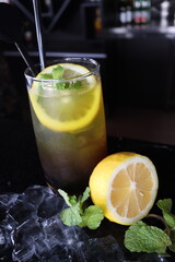 cold water with a slice of lemon fruit and mint leaf