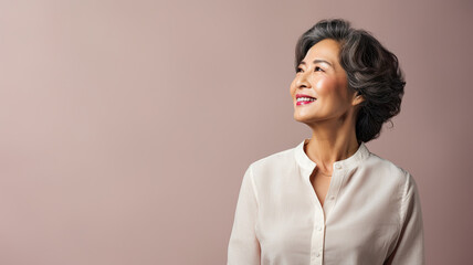 older Asian woman with gray hair, in profile, wearing pink shirt. Copy space