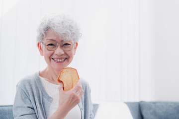 食パンを食べるシニアの女性