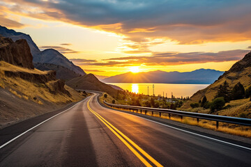 Asphalt road through hilly terrain at sunset.