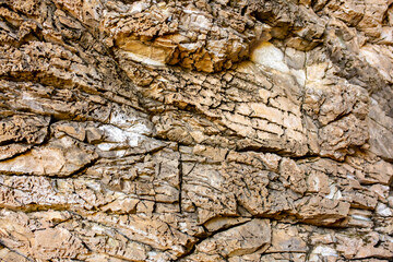 Natural rock texture background. Rocky bas-relief wall.