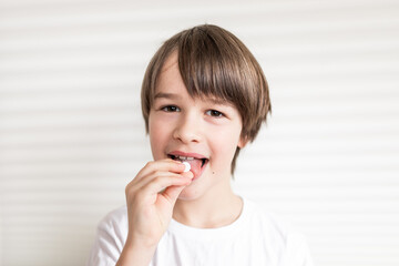 Fototapeta na wymiar Happy boy puts the pill into his mouth. Close up portrait of child with pill on hes tongue at home ,taking medicine, taking vitamins,medical, nutrition, healthcare concept