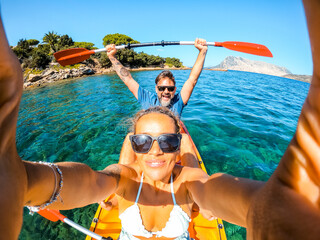Overjoyed couple of caucasian adult tourist man and woman taking selfie picture inside a kayak...
