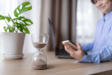 Hourglass on the table for business deadline. Time concept