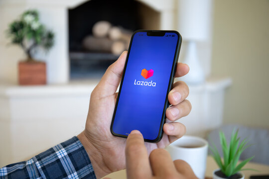 Man hands holding iPhone 14 online Internet shopping service Lazada
