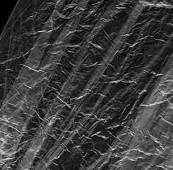 Wrinkled plastic wrap texture on a black background wallpaper. Royalty high-quality free stock photo image of realistic plastic wrap for overlay, copy space and photo effect. Wrinkled plastic surface