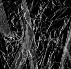 Wrinkled plastic wrap texture on a black background wallpaper. Royalty high-quality free stock photo image of realistic plastic wrap for overlay, copy space and photo effect. Wrinkled plastic surface