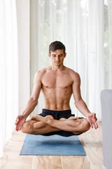 Fotobehang Lotusbloem Middle aged yoga man levitating in lotus pose over the mat  © skumer