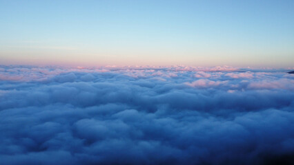 Aerial view over the mountains with sea of fog during morning sunrise in blue sky. Sea of clouds around mountain peaks at sunrise. Unseen travel in Northern Thailand