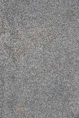Granite texture. Natural gray granite with a grainy pattern. Stone background. Solid rough surface of rock. Durable construction and decoration material. Close-up.