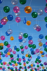 Fototapeta na wymiar Ballons multicolores suspendus sous le ciel