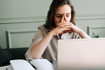 Stressed and Overworked Young Woman with Laptop, Battling Fatigue, Pressure, Migraine, and Stress....