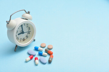 A pile of drugs and clocks on a blue background