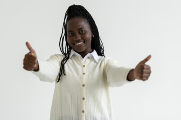 Cheerful african woman giving thumb up on white background