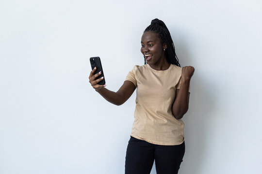 Young african make selfie on the phone with win gesture on white background