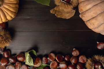 Chestnuts and pumpkins on a wooden table flat lay background