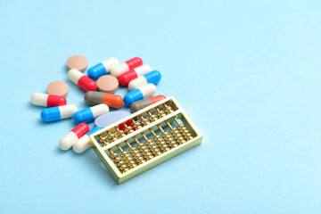 An abacus placed on a pile of drugs on a blue background