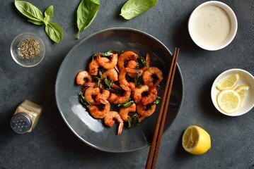 Roasted shrimp with basil leaves in bowl