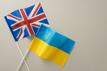 Capture the essence of Ukraine's global alliances with a top view image of Ukrainian and UK flags against a muted gray backdrop. Ample space for your message or advertisement