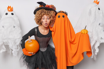 Holiday celebration concept. Indoor photo of young beautiful African american lady in witch costume...