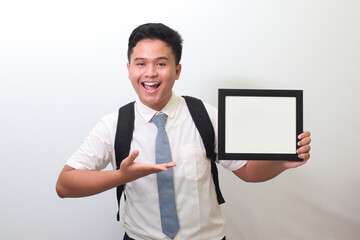Indonesian senior high school student wearing white shirt uniform with gray tie showing empty...