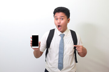 Indonesian senior high school student wearing white shirt uniform with gray tie showing and presenting blank screen mobile phone. Isolated image on white background