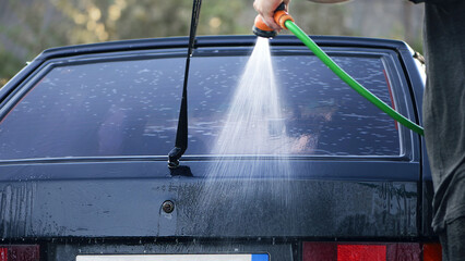 water from a hose from a spray bottle washes the car. Car washes use high pressure water sprays,...