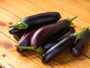 A heap of eggplants on a wooden background