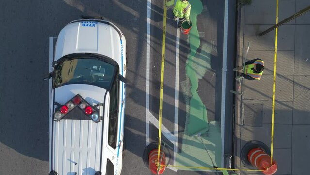 flying over workers painting bike lane in Brooklyn NY