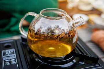 A transparent kettle is heated on an electric stove. The tea is boiling.