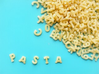 Alphabet pasta and the word pasta on a blue background