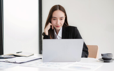 Asian businesswoman calculate financial graphs showing results about their investments and planning successful business growth processes in the office