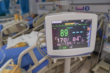 Modern vital sign monitor on patient background at ward in the hospital.