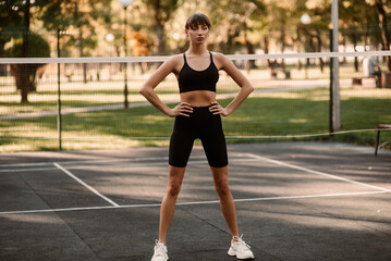 A young female trainer performs a fitness compression exercise. The girl is working out outdoors....