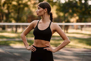A young female trainer performs a fitness compression exercise. The girl is working out outdoors....