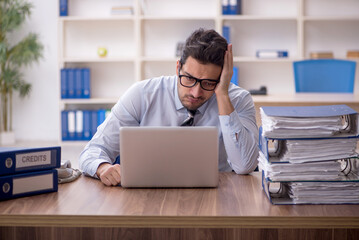 Young male employee and too much work in the office