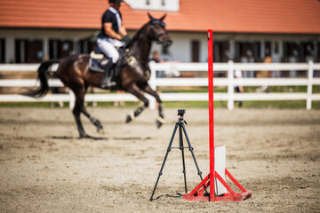 Timer or digital stopwatch at the finish line. Horse equestrian show jumping competition. Defocused...