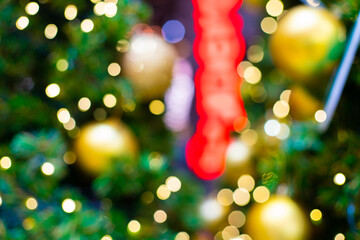 Obraz na płótnie Canvas Golden christmas ball on pine tree branch green leaf blurred bokeh background merry christmas