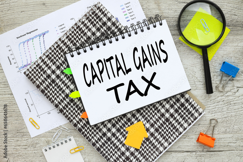 Poster capital gains tax cgt. notepad with text. notes in a notepad. magnifying glass