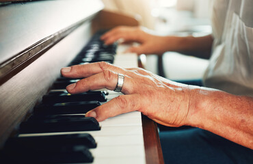 Hands, piano and senior man playing for music in living room for musical entertainment practice. Instrument, hobby and elderly male person in retirement enjoying a song on keyboard at modern home. - Powered by Adobe